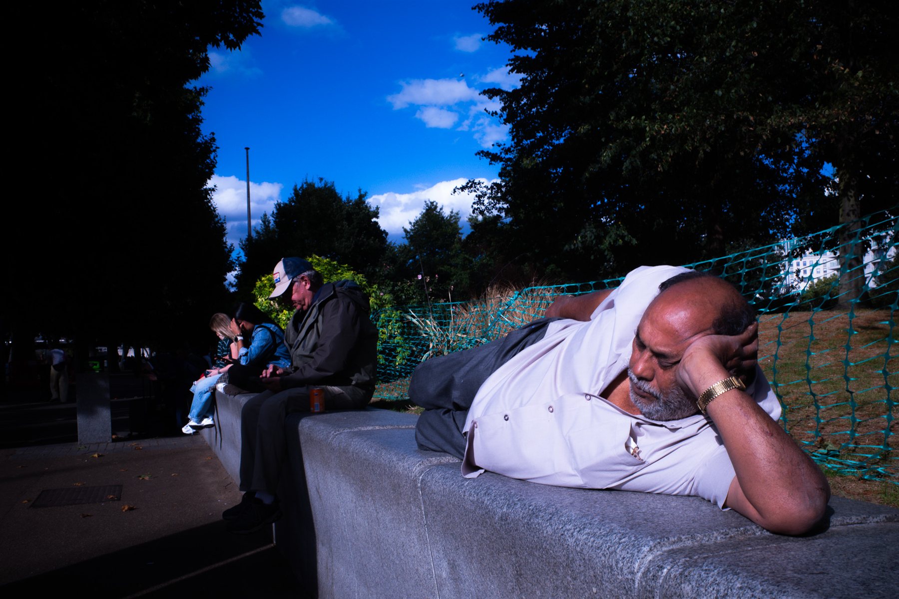 A man asleep on a park bench in London
