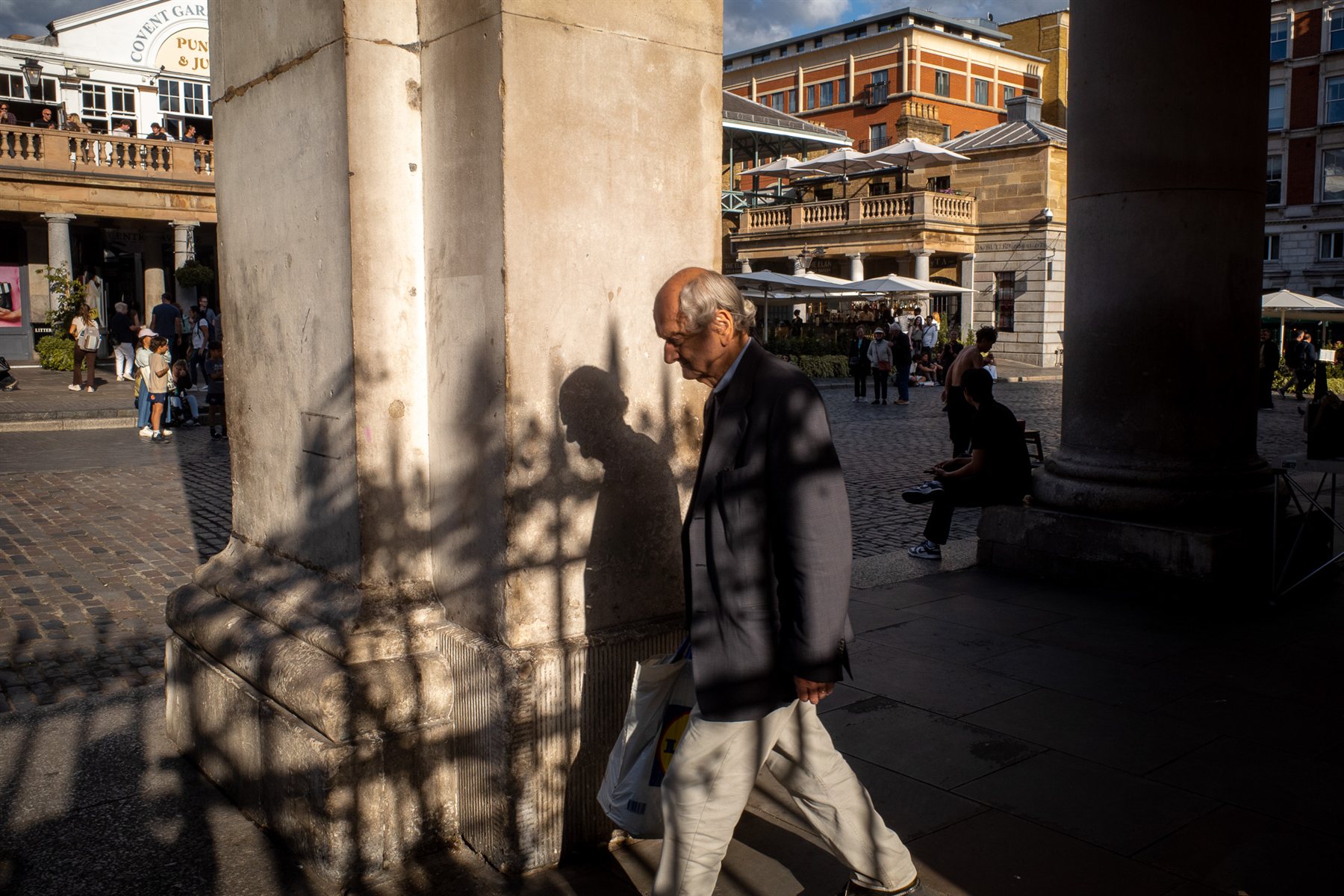 A man's silhouette walking through Covent Garden colonnade